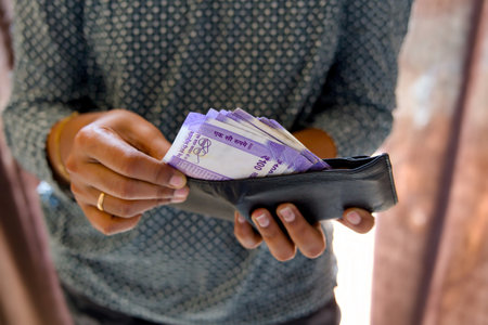 woman holding a wallet full of Indian rupee notes in his handの写真素材