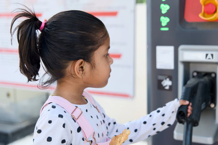 Cute Asian child girl holding an ev car electric charger