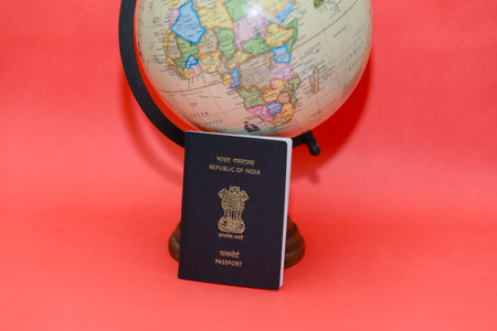 passport and globe on a red background, travel concept, copy spaceの写真素材