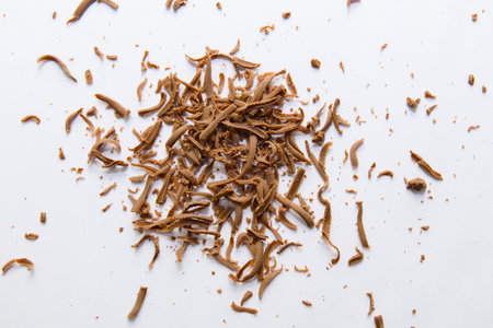 A heap of finely grated chocolate shavings on a pristine white surface. Ideal for culinary backgrounds and textures.の写真素材