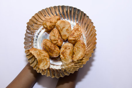 Delicious fried momos served fresh on a plate against a pristine white background.の写真素材
