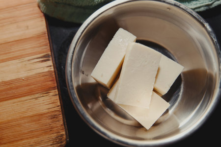 A steel bowl holds fresh paneer cubes, perfect for Indian cuisine. Cooking, flavor, and texture come togetherの写真素材