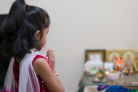 Asian little girl praying to god in the living room at home.の写真素材