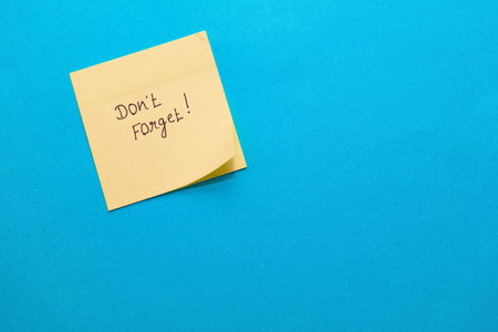 A simple yellow sticky note on blue, perfect for adding your reminder!の写真素材