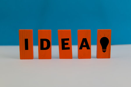 Bright orange blocks spell IDEA with a lightbulb, symbolizing innovation and creative thinking.の写真素材