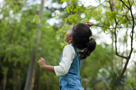 Curious little girl explores the lush green forest, her eyes sparkling with wonder and joy.