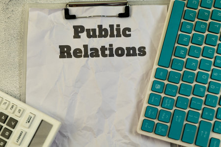 Public relations concept. Text on crumpled paper with keyboard and calculator.の写真素材