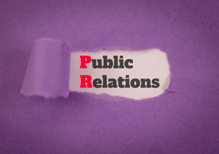 Public relations message revealed beneath torn purple paper. Concept of PR, communication, and marketing.の写真素材
