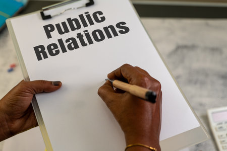 Hands crafting a PR plan on a clipboard. Ready for your message!の写真素材