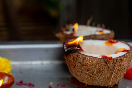 Burning coconut oil lamps with turmeric & kumkum powder, used in Hindu puja rituals.  Spiritual offering with flowers & diya.の写真素材