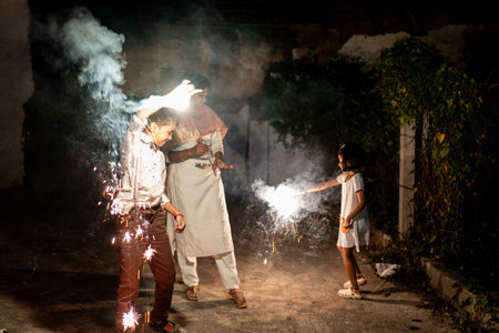 Indian family celebrates Diwali with sparklers, lighting up the night with joy and tradition.
