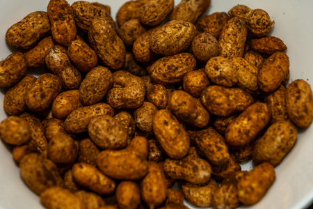 Bowl of delicious roasted peanuts in shell, perfect for snacking. Warm, earthy tones.の写真素材
