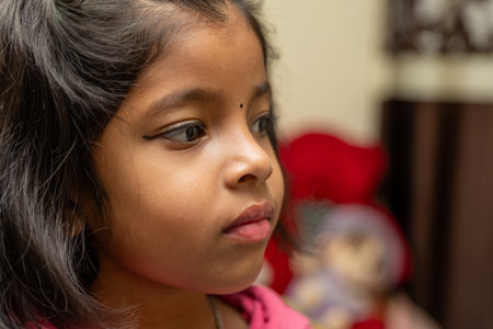 A young girl gazes thoughtfully into the distance, her eyes full of wonder and curiosity.