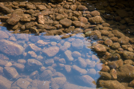 Water surface of a river with stones in the foreground. Selective focus.