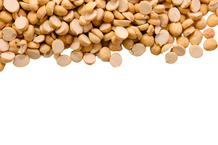 Dried chickpeas are scattered on a clean white background, showcasing their round shapes and beige...
