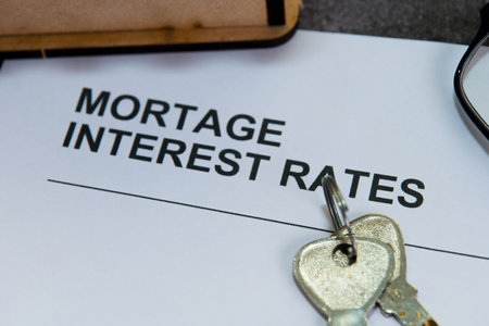 Document showing mortgage interest rates with house keys on table, highlighting home buying decisions.の写真素材