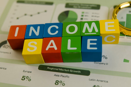 Colorful building blocks display the words income and sale on a financial report with charts and...