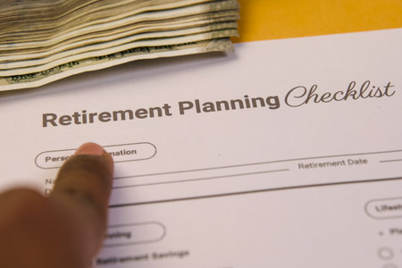 A person points to a retirement checklist surrounded by money, highlighting the importance of financial readiness.の写真素材