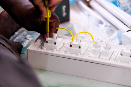 Technician assembles electrical connectors in a workshop, ensuring precise connections and safety.