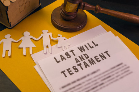 Last will and testament documents arranged with family paper cutouts and a gavel on a yellow...