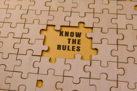 A puzzle with one missing piece revealing a yellow background and the message Know the Rules, symbolizing guidance.の写真素材