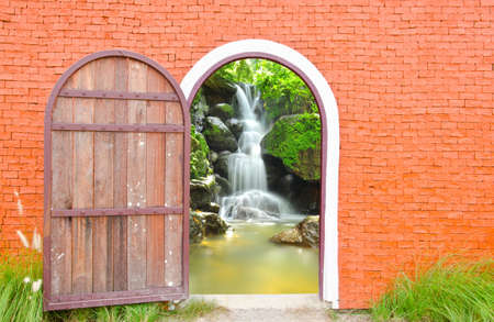Old door wooden is open to waterfall wallの写真素材