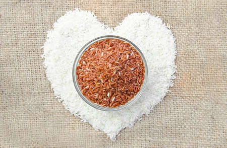 raw Thai jasmine rice and raw brown rice heart shape on sack の写真素材