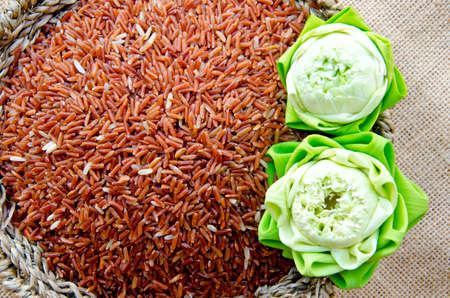Raw brown rice and lotus flower in Basket weave on sack backgroundの写真素材