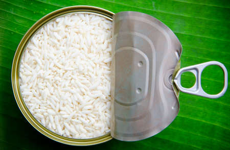 Raw sticky rice in can on leaves background