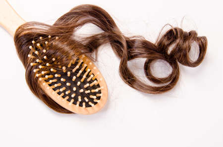 wooden comb brush with hair, on white backgroundの写真素材