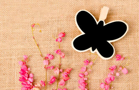 Black wood clip and flower on sack backgroundの写真素材