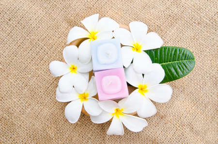 plumeria blossom and candles on sack backgroundの写真素材
