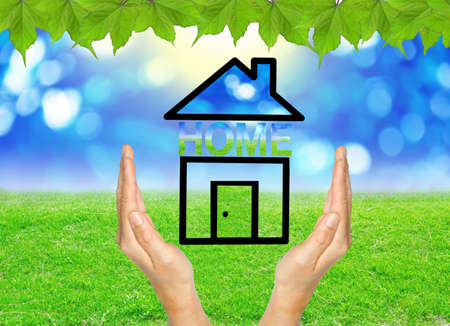 Home in hands on green spring background.の写真素材