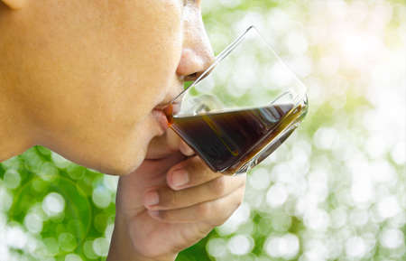 close up the mouth of man drinking coffee  on spring sunny nature backgroundの写真素材