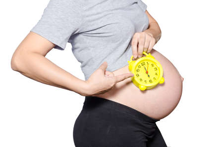 Pregnant woman\'s belly with clock. 