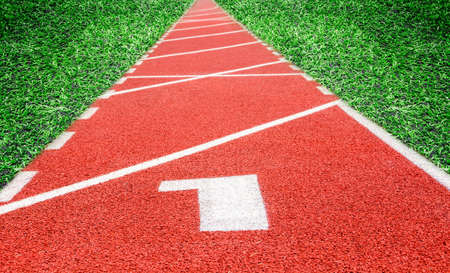 Start track. Lanes 1 number one on red racing track and grass background.の写真素材