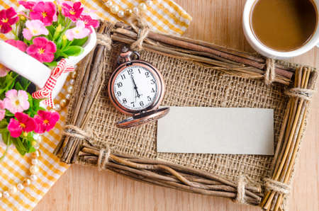 Vintage paper blank tag and clock with fram and flower on wooden background.の写真素材