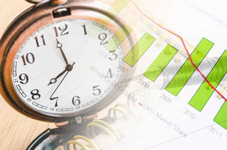 Business time concept with clock and graph documentsの写真素材