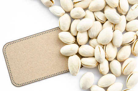 Natural Pistachio nuts and brown tag on white background.の写真素材