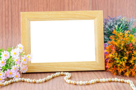 Blank wooden photo frame and flower on wooden backgroundの写真素材