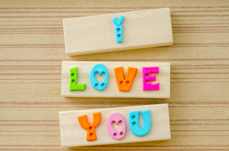 Inscription I LOVE YOU made of colorful letters on wooden backgroundの写真素材