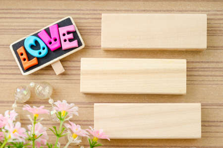 LOVE wording and blank wooden tag with flower on wooden background.の写真素材