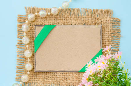 Blank brown tag paper recycle with flower on sack background for your text.の写真素材