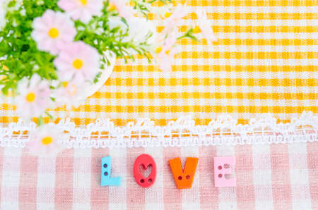 Love aphabet with flower on beautiful fabric background. Love concept.の写真素材