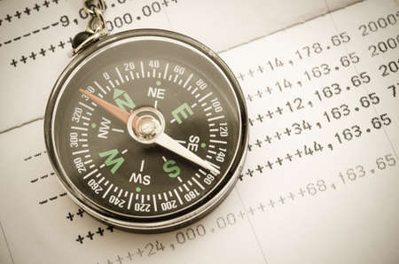 Vintage of compass and book bank statement. Financial direction concept.の写真素材