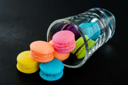 Colorful macaroons in glass on over black backgroundの写真素材