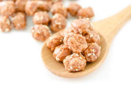 Honey roasted coated peanuts and white sesame seeds on white background.の写真素材