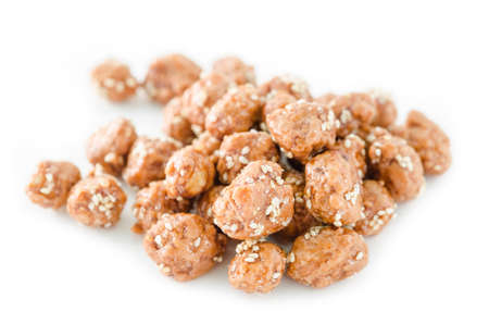 Honey roasted coated peanuts and white sesame seeds on white background.の写真素材