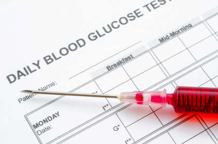 Daily blood glucose testing and sample bloodin syringe. Blood sugar control concept.の写真素材