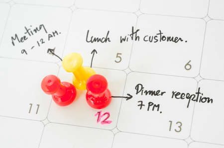 Pushpin on calendar with busy day overworked schedule.の写真素材